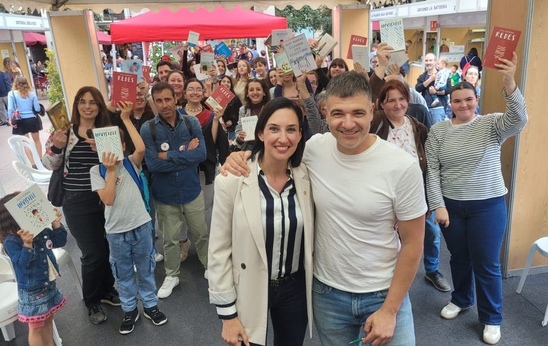 La concejala de cutura Mde Castellón María España Jutno al autor Eloy Morino y tras ellos decenas de lectores mostrando sus libros en alto