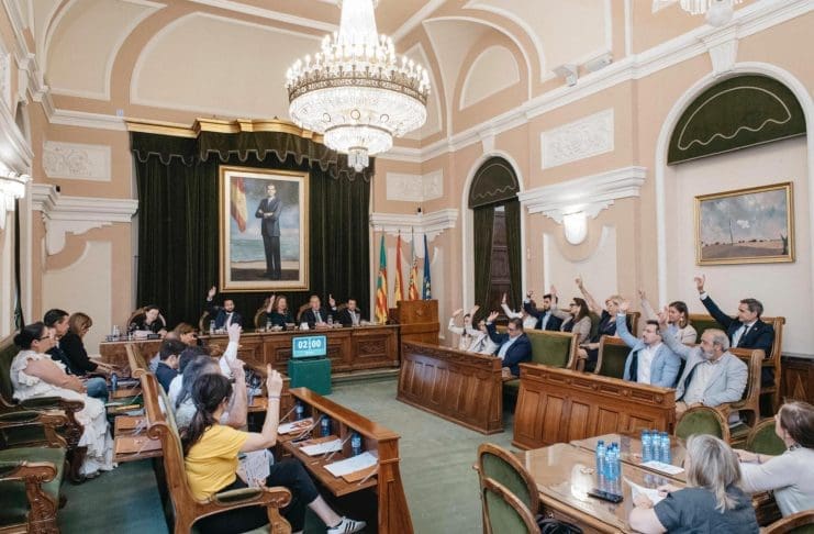 Imagen del salón de plenos de Castellón con los ediles con las manos alzadas durante una votación.