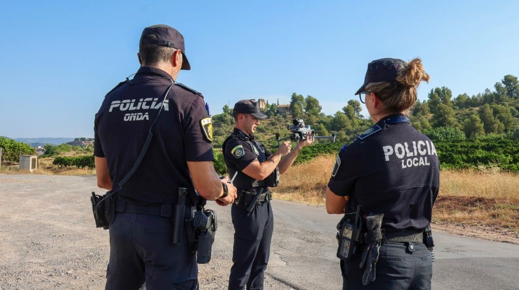 Imagen de tres agentes de policía local de Onda de espaldas al aire libre observando un drom