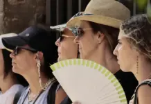 Sanidad eleva a rojo el riesgo por calor en el interior de Castellón y deja en naranja la costa Varias personas se protegen del calor con gorras y abanico