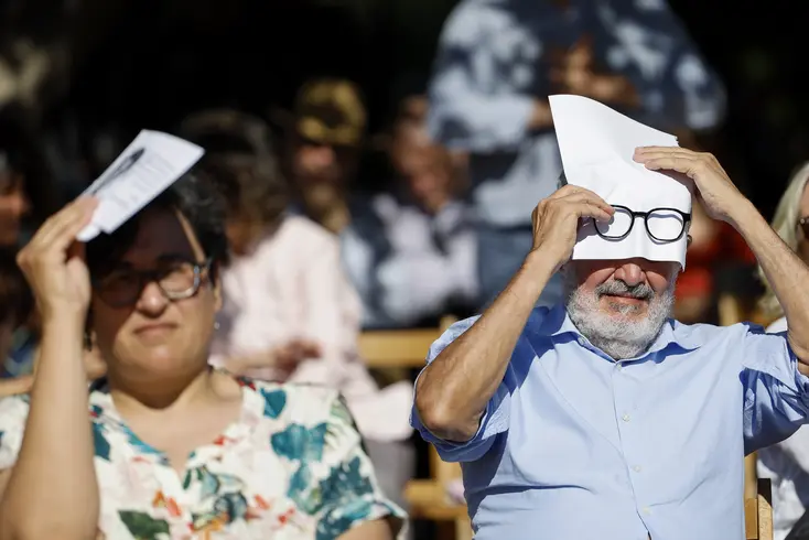 Dos personas se protegen del sol y del calor al aire libre.